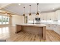 Bright, modern kitchen with white cabinets, a center island, and stainless steel appliances at 4711 H D Atha Rd, Covington, GA 30014