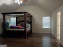 A bedroom with high ceilings, wood floors and a large, four-poster bed, creating a Primary suite at 1253 Heartwood Ave, Mcdonough, GA 30253