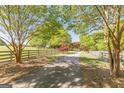 Long driveway bordered by a wooden fence and mature trees, leading to the home at 13819 Woolsey Rd, Hampton, GA 30228