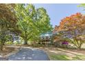 Beautiful home with brick and siding exterior, complemented by mature trees and landscaping in a serene setting at 13819 Woolsey Rd, Hampton, GA 30228