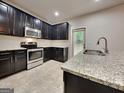 Modern kitchen featuring granite countertops, stainless steel appliances, and sleek dark cabinets at 1162 Ida Woods Ln # 23, Lawrenceville, GA 30045