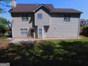 View of the home's rear exterior featuring vinyl siding and a well-maintained yard at 7541 Coddington Ct, Riverdale, GA 30274