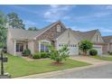 Exterior view of a well-maintained home, with a two-car garage, manicured lawn and stone facade at 203 Collierstown Way, Peachtree City, GA 30269