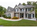 This two-story home features a well-kept lawn, beautiful landscaping, and a classic architectural design at 6205 Collingham Trce, Cumming, GA 30040
