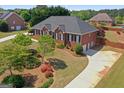 Expansive aerial view of a brick home with lush landscaping and circular driveway at 130 Gillson Dr, Mcdonough, GA 30253