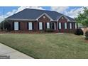 Charming brick home featuring manicured front lawn and classic black shutters at 130 Gillson Dr, Mcdonough, GA 30253