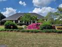 Inviting brick home enhanced by colorful azaleas and lush landscaping at 130 Gillson Dr, Mcdonough, GA 30253