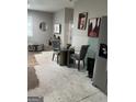 Open-concept living area with modern decor, round table with gray chairs, and stainless steel refrigerator at 690 Mcdonough Se Blvd, Atlanta, GA 30315