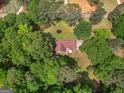 Aerial view of a single-story home surrounded by lush greenery and mature trees at 1710 Crumbley Rd, Mcdonough, GA 30252