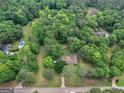 Aerial view of a wooded property featuring a home and pool surrounded by mature trees at 1710 Crumbley Rd, Mcdonough, GA 30252