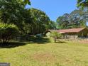 Fenced backyard with mature trees and lush lawn perfect for outdoor activities and relaxation at 1710 Crumbley Rd, Mcdonough, GA 30252
