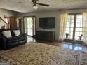 Cozy living room with a comfortable black sofa, a large rug, and natural light from the windows at 96 Daniel Ct, Mcdonough, GA 30253