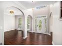 Bright foyer with hardwood floors, arched doorways, and a decorative glass front door at 1085 Crown River Pkwy, Mcdonough, GA 30252
