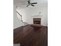 Spacious living room with a fireplace, hardwood floors, and staircase access at 5114 Verbena Nw Dr, Acworth, GA 30102