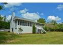 Exterior view of a home featuring a spacious screened porch and well-maintained lawn at 301 Spruill Bridge Rd, Temple, GA 30179