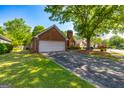 Well-manicured lawn and landscaping accentuate this lovely brick home with attached two car garage at 140 Carriage Chase, Fayetteville, GA 30214