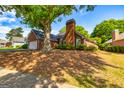 Well-maintained brick house with mature trees, a two-car garage, and manicured landscaping at 140 Carriage Chase, Fayetteville, GA 30214