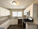Updated kitchen features granite countertops, white cabinets, and stainless steel appliances at 1962 Marvin Sw Ln, Atlanta, GA 30311