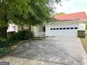 Well-maintained single-story home with a red roof, a two-car garage, and a concrete driveway at 3041 Regal Dr, Mcdonough, GA 30253