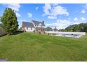 Expansive backyard featuring a well-maintained lawn, fenced pool area, and mature trees offering privacy at 125 Anna Dr, Covington, GA 30014