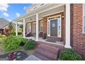 Charming front porch with brick steps, columns, and a welcoming door, perfect for relaxing outdoors at 125 Anna Dr, Covington, GA 30014