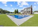 Backyard view of a sparkling in-ground pool with lounge chairs, patio, and a grassy area, ideal for outdoor entertaining at 125 Anna Dr, Covington, GA 30014