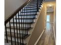 A modern staircase with wood steps, white risers and black metal railing, leading to the upper level at 1853 Broad River Rd, Atlanta, GA 30349