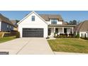 Beautiful exterior view of a two story home with a large black garage door and landscaped front yard at 15 Dayton Way, Sharpsburg, GA 30277