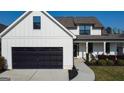 Lovely two-story home with black garage door, white siding and a charming front porch at 15 Dayton Way, Sharpsburg, GA 30277