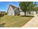 Well-maintained home showcasing a spacious lawn and mature trees at 4893 River Overlook Way, Lithonia, GA 30038