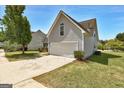 Attached two-car garage with an adjacent, well-kept lawn at 4893 River Overlook Way, Lithonia, GA 30038