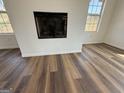 The electric fireplace in a room featuring durable flooring and windows at 2873 Shoals Hill Ct, Dacula, GA 30019