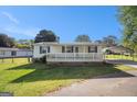 Home with a quaint front porch, carport, and well-kept lawn, offering curb appeal and functionality at 73 Highpoint Ln, Locust Grove, GA 30248