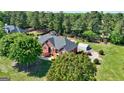 Aerial view of brick home with lush landscaping, a circular driveway, and large detached garage at 220 Edna Ruth Ln, Mcdonough, GA 30253