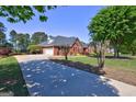 Well-maintained brick home with a long driveway, mature trees, and lush green lawn at 220 Edna Ruth Ln, Mcdonough, GA 30253
