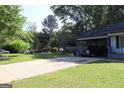 Long driveway with a carport to the right of a single-story home and lots of trees at 4793 Davenport Nw Trce, Acworth, GA 30101