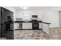 Classic kitchen featuring white cabinets, black appliances, and sleek countertops, blending style with functionality at 4448 Janice Dr, Snellville, GA 30039