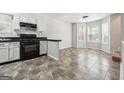 Open-concept kitchen featuring white cabinets, black appliances and countertops, seamlessly connected to a dining area at 4448 Janice Dr, Snellville, GA 30039