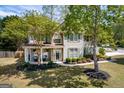 Inviting two-story house featuring stone details, a cozy front porch with seating, and lush greenery at 1212 Dayspring Trce, Lawrenceville, GA 30045