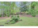 Two story house amongst mature trees and lush landscaping viewed from the vast front lawn at 100 Ashland Trl, Tyrone, GA 30290