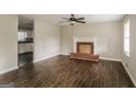 Inviting living room with hardwood floors, decorative fireplace, and a glimpse into the adjacent kitchen at 6024 S Deshon Ct, Lithonia, GA 30058