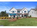 Beautiful two-story home with a lush green lawn, shrubs, and manicured landscaping at 284 Villa Grande Dr, Locust Grove, GA 30248