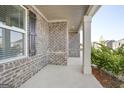 Covered porch with brick accents, offering a cozy outdoor space at 1144 Bluecoat Cir, Hampton, GA 30228