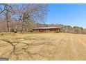 Brick home nestled on a vast lot with mature trees and a sprawling lawn in a rural setting at 461 Old Jackson Rd, Mcdonough, GA 30252