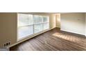 Living room featuring newly installed hardwood floors, neutral paint, and large window allowing natural light to fill the space at 2099 Yucca Dr, Decatur, GA 30032