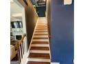 Staircase featuring wooden treads and white risers with dark accent wall at 3168 Spicy Cedar Ln, Lithonia, GA 30038