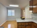Kitchen with wood cabinets, granite countertops, and hardwood floors at 7665 Antebellum Ln, Riverdale, GA 30274