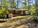 View of the backyard featuring a brick house with a wooden deck and partially fenced yard at 1815 Dodson Sw Dr, Atlanta, GA 30311