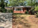 Charming one-story brick house with a carport and well-maintained front yard, nestled among mature trees at 1815 Dodson Sw Dr, Atlanta, GA 30311