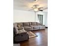 Inviting living room featuring hardwood floors, a ceiling fan, and a large sectional sofa at 11755 Highway 36, Covington, GA 30014